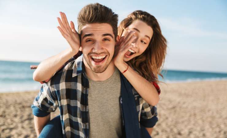 Ragazza sulle spalle di un ragazzo sorridente